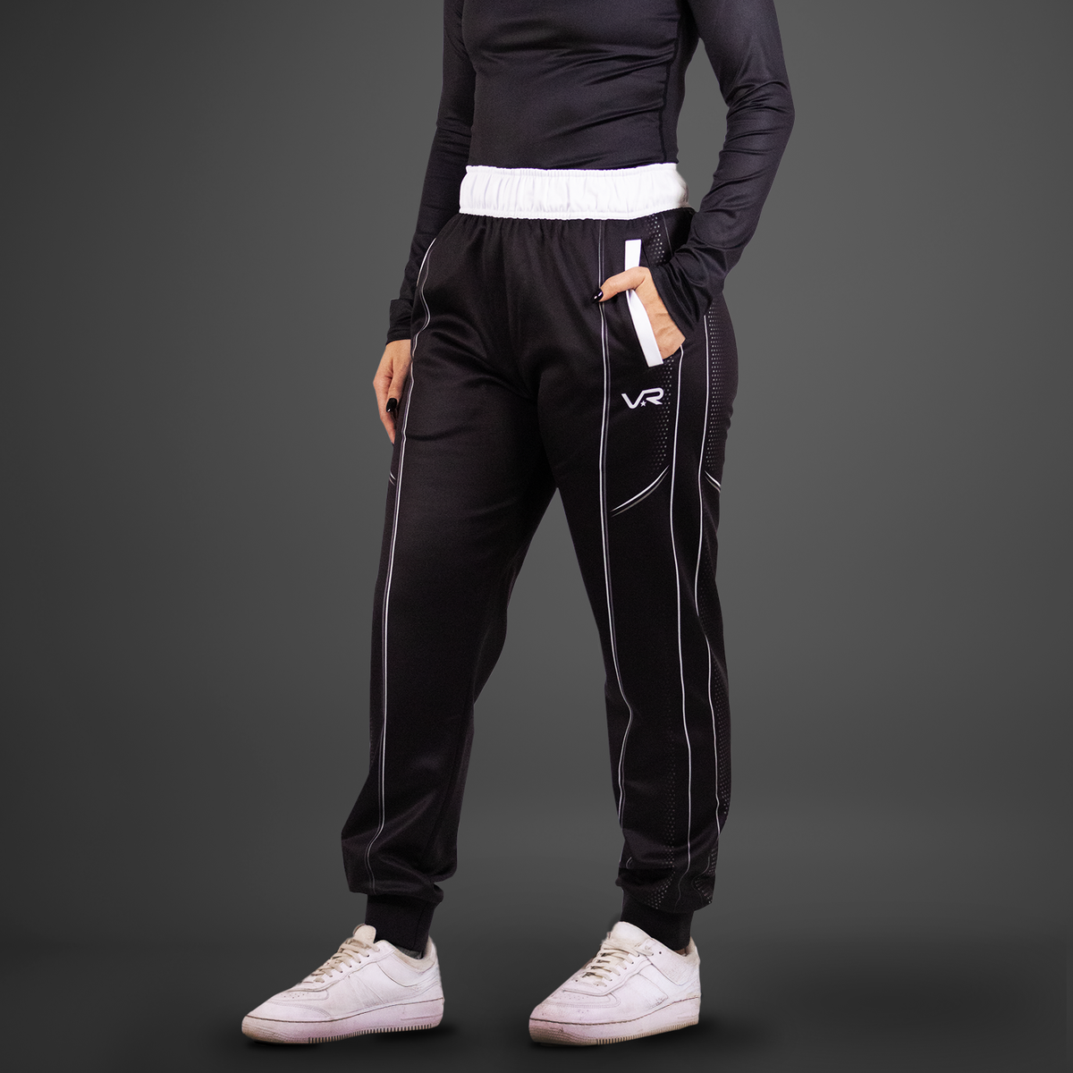 Person wearing black VR tracksuit with white accents on a gray background