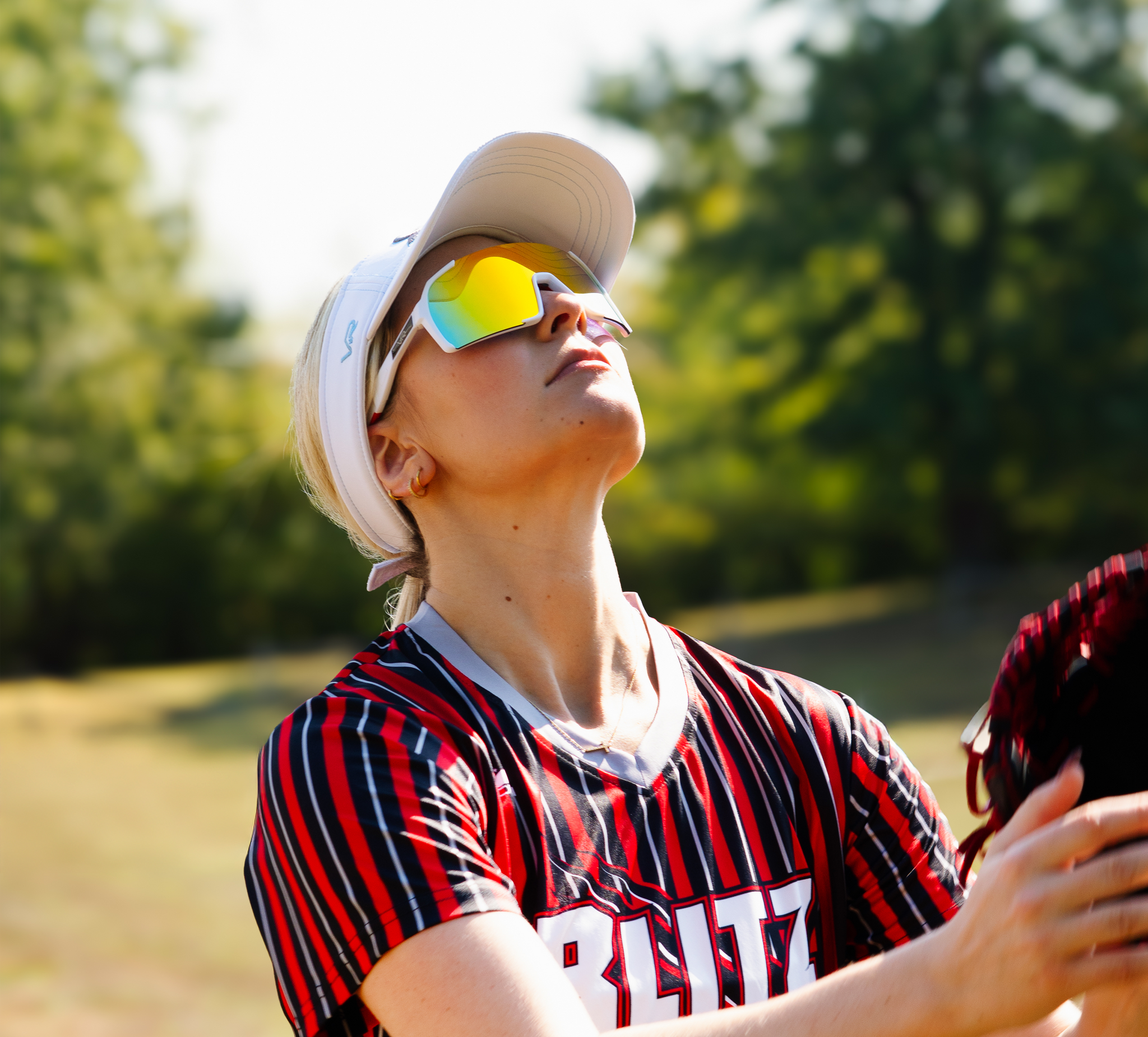 Person wearing colorful sunglasses and a striped shirt outdoors