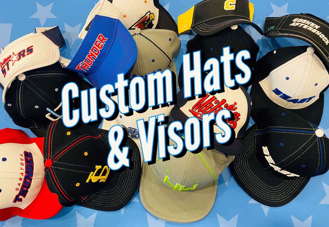 Custom hats and visors in a pile on a blue flag