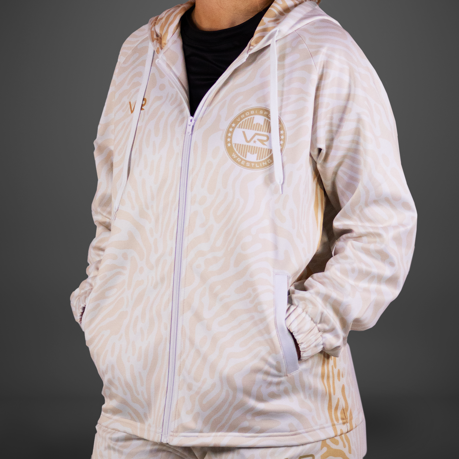 A cream and tan full zip hoodie with animal pattern on a grey background.