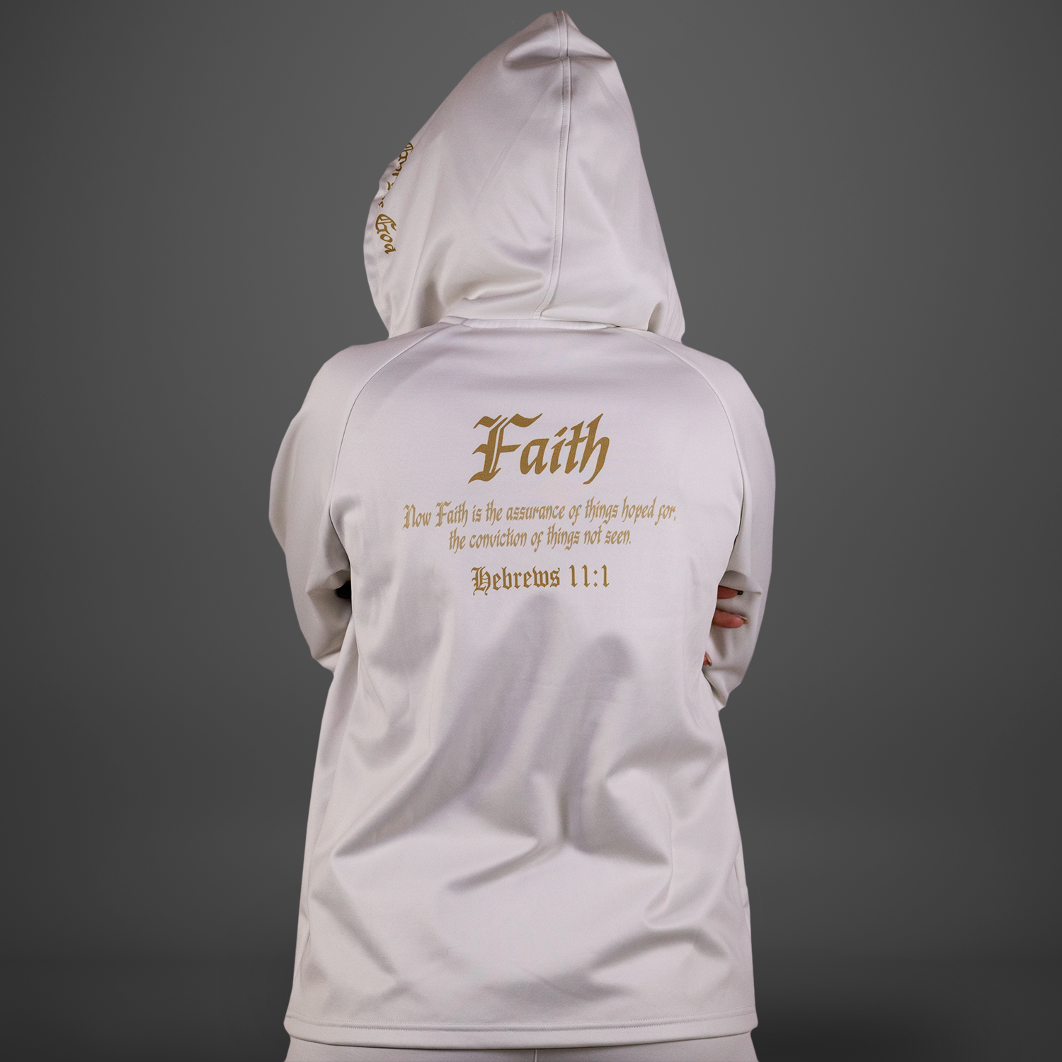 White hoodie with 'Faith' text on the back against a gray background