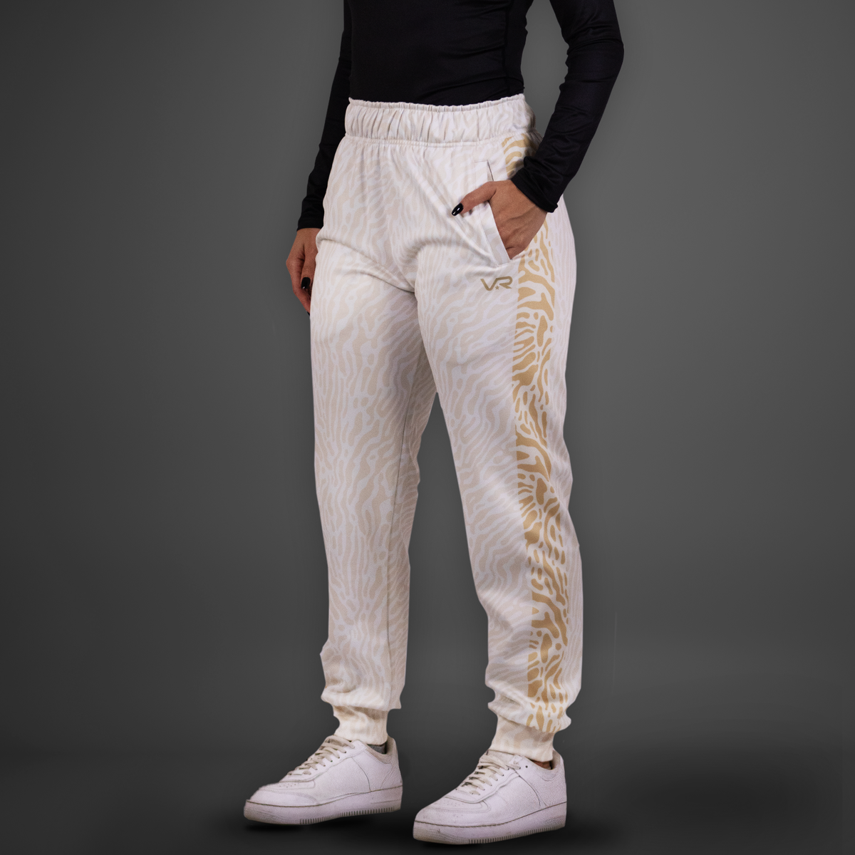 White jogger pants with gold design on a gray background